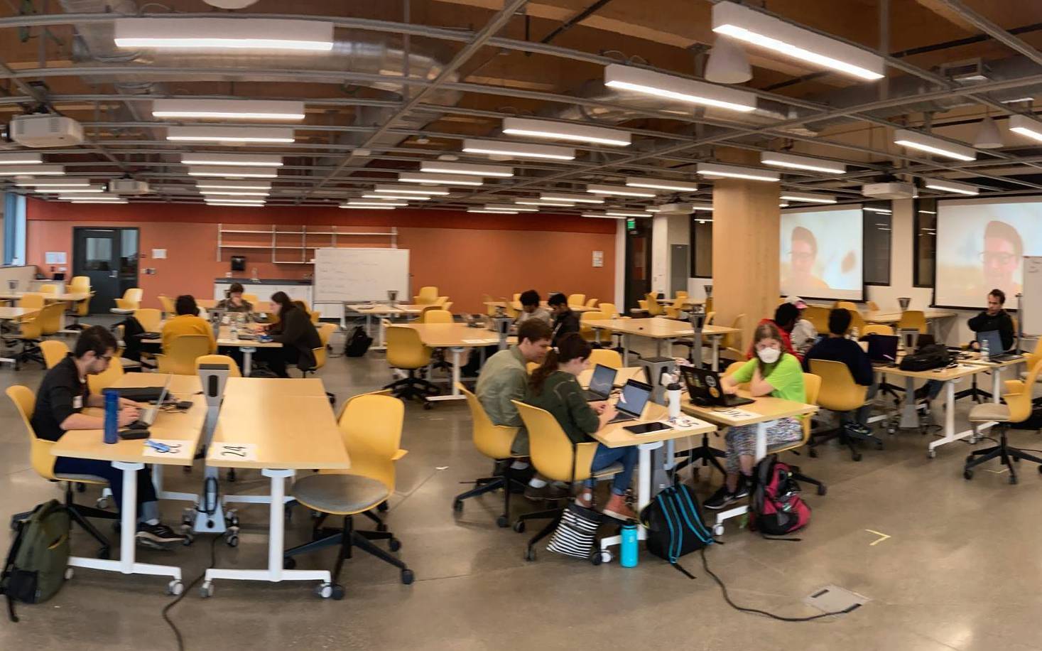 students sit in groups around computer