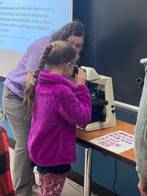 Girl looking through microscope